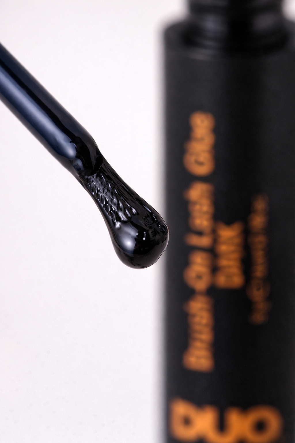 brush-on lash glue with dark eyeliner effect